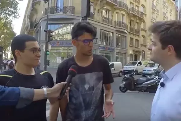 Deux jeunes en tee-shirt et lunettes discutent avec un homme en chemise dans la rue